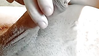 A guy in a crimson T-shirt ejaculates in close-up on his body, shows nut-juice